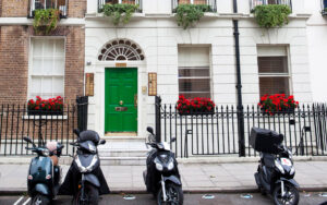 A shot of the entrance of 10 Fitzroy Square, Fitzrovia, London West End showing street parking bays with scooters parked in them