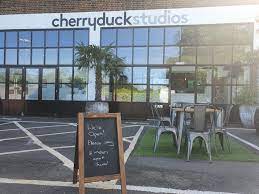External shot of Cherryduck Studios, 12-18 Sampson Street, Tower Hamlets, London E1W 1NA with A board in the foreground