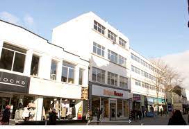 A shot of Ascent Properties, 238-239 Oxford Street, Swansea, SA1 3BL showing the surrounding high street stores and high foot fall