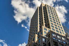 Looking up at the Bevmax Office Centers - 667 Madison Avenue, New York, NY, 10065 office building with clouds in the distance
