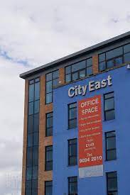 The exterior of City East Business Centre in Belfast with an office space to rent sign on it