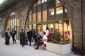 The entrance to the Hotel Elephant workspace in Southwark with people socialising outside