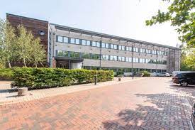 Wide shot of Regus - John Eccles House, Robert Robinson Avenue, Oxford Science Park, Oxford, Oxfordshire OX4 4GP office building with car park