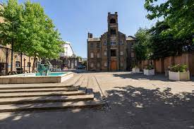 The exterior of Grow Studios, Alice Billings House, West Ham Lane, Stratford, London, E15 4SF on a sunny day with the decorative pool in the foreground