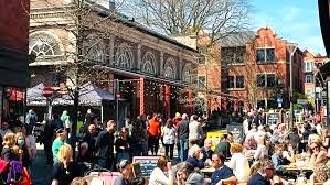 A bustling day in Altrincham town centre with images of people eating and drinking outside Altrincham Market