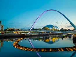 A view of the Gateshead Millennium Bridge over the River Tyne and The Glasshouse in the background