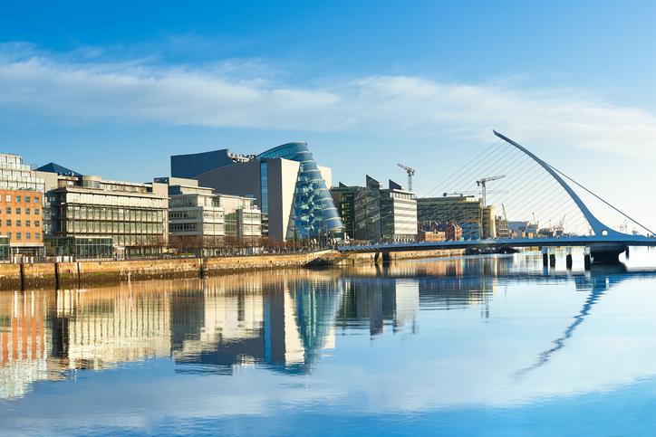 Dublin office buildings on the River Liffey and the Samuel Beckett Bridge aka the Harp Bridge, on a sunny day